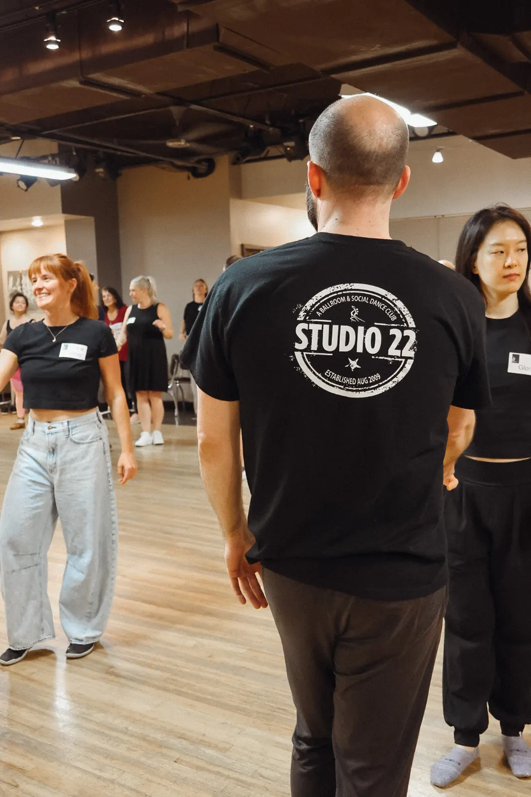 Smiling follow dancer next to a student in a Studio 22 shirt