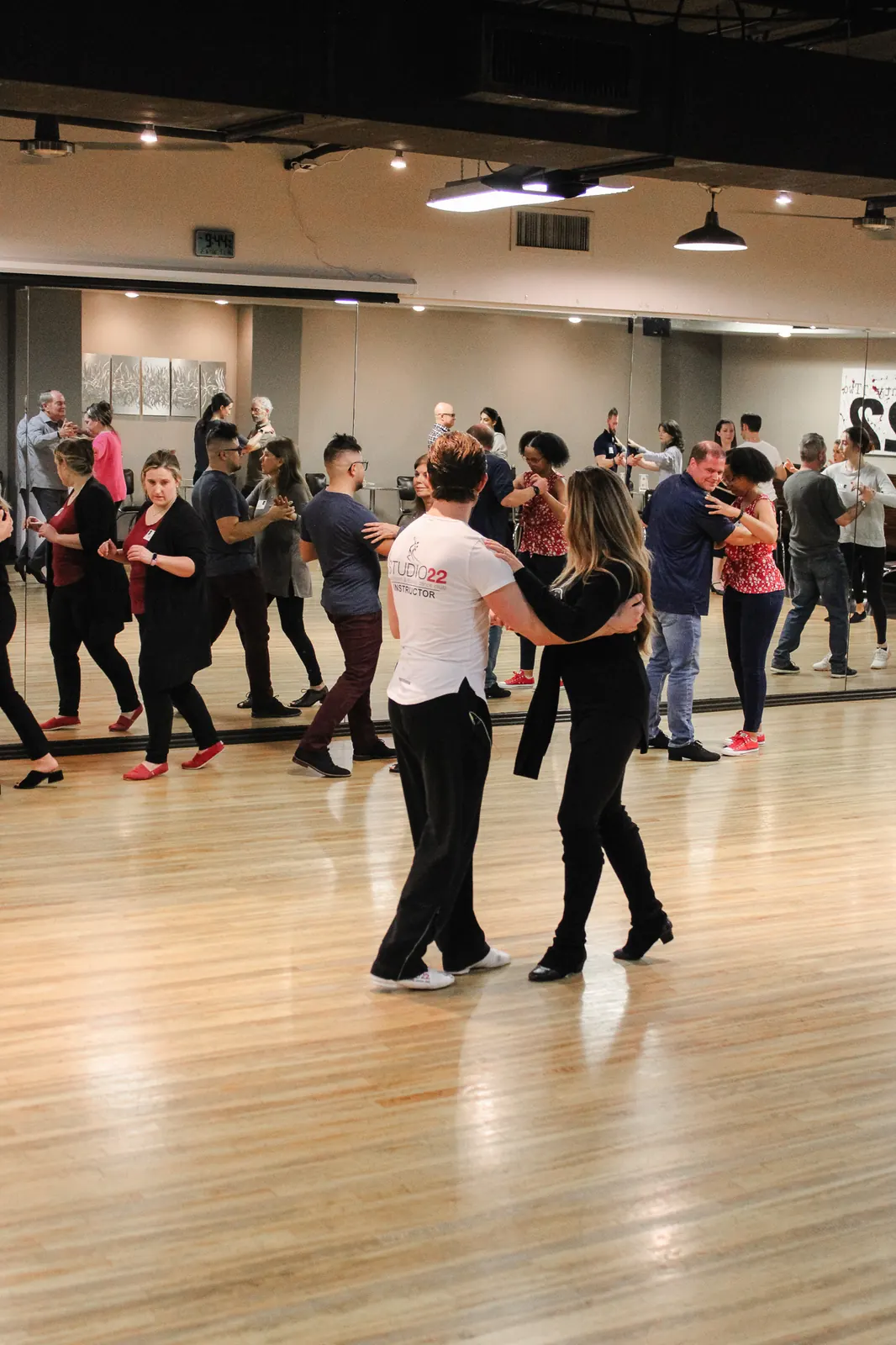 Instructors teaching salsa to a room of students at Studio 22