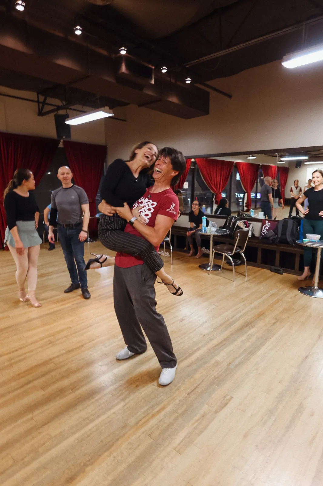 Couple smiling mid-lift during tango class at Studio 22